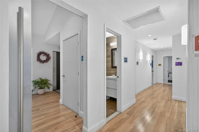 a view of a hallway with wooden floor and closet