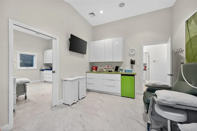 a kitchen with a refrigerator and white cabinets