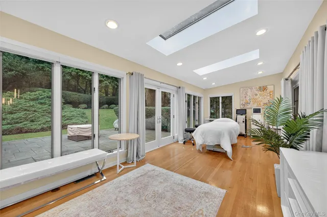 a bedroom with a bed and large windows