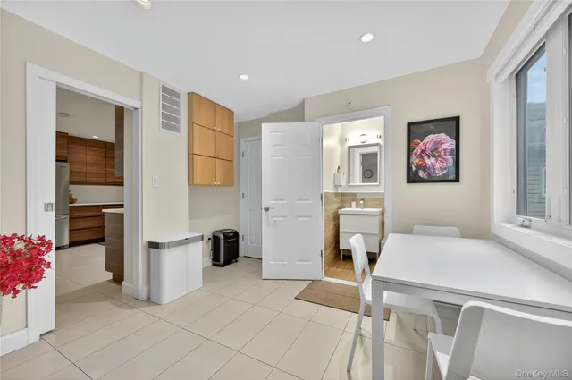 a living room with furniture and a refrigerator