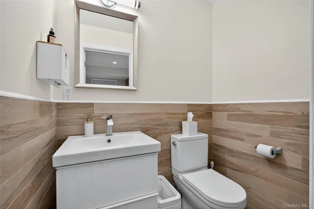 a bathroom with a toilet sink and mirror