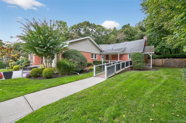 a view of a house next to a big yard and large trees