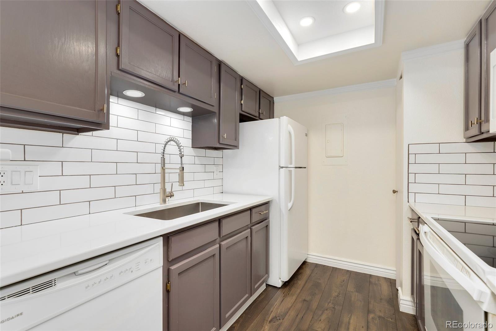 8335 Fairmount Drive, Unit 1202 Denver, CO 80247 - Photo 12 of 28 a kitchen with a sink and refrigerator