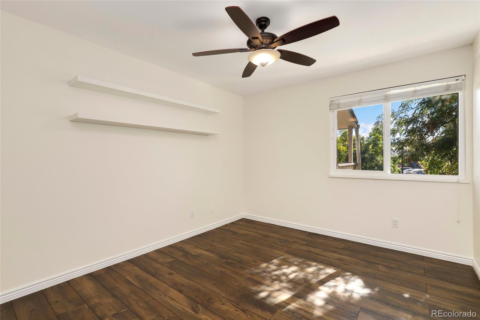 8335 Fairmount Drive, Unit 1202 Denver, CO 80247 - Photo 17 of 28 an empty room with wooden floor and windows