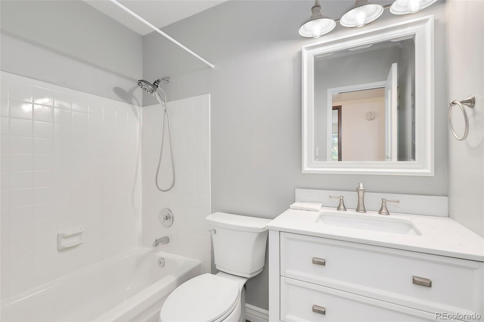 8335 Fairmount Drive, Unit 1202 Denver, CO 80247 - Photo 19 of 28 a bathroom with a sink toilet vanity and shower