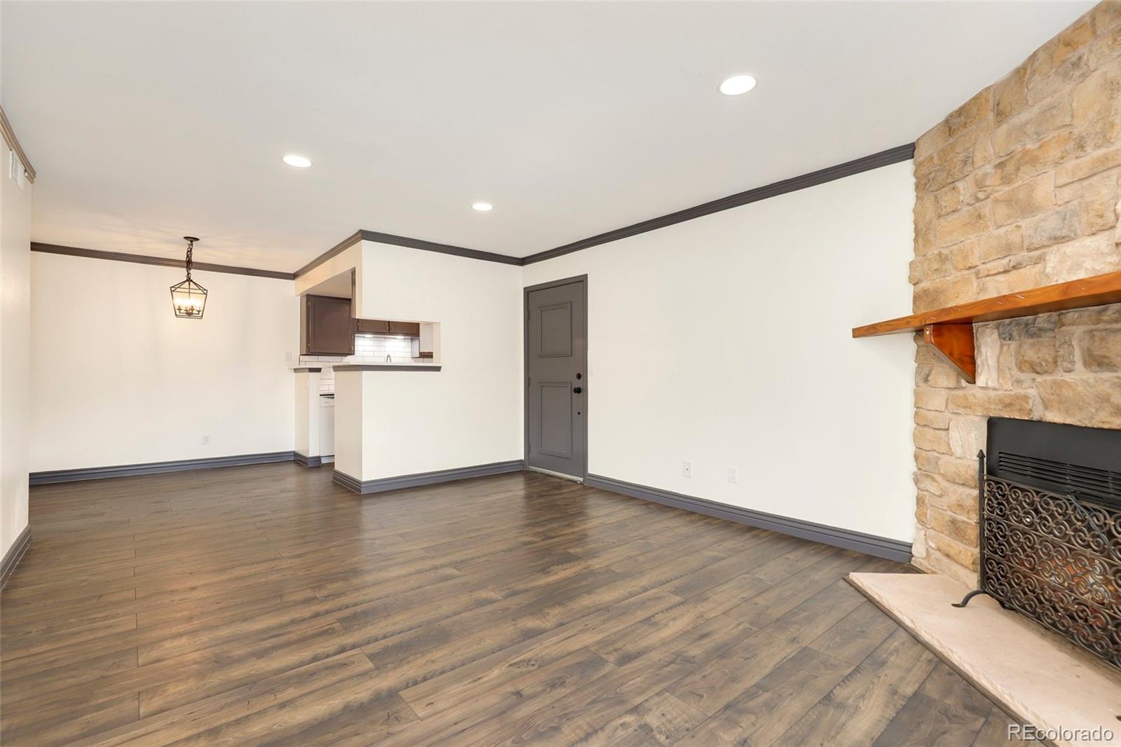 8335 Fairmount Drive, Unit 1202 Denver, CO 80247 - Photo 7 of 28 a view of empty room with wooden floor and fireplace
