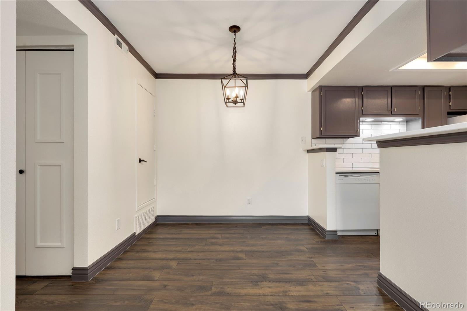 8335 Fairmount Drive, Unit 1202 Denver, CO 80247 - Photo 9 of 28 a view of a kitchen with a white kitchen stove a refrigerator and wooden floor
