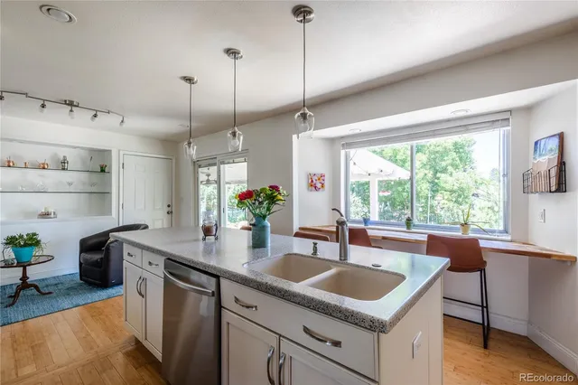 a kitchen with stainless steel appliances granite countertop sink stove and wooden floor