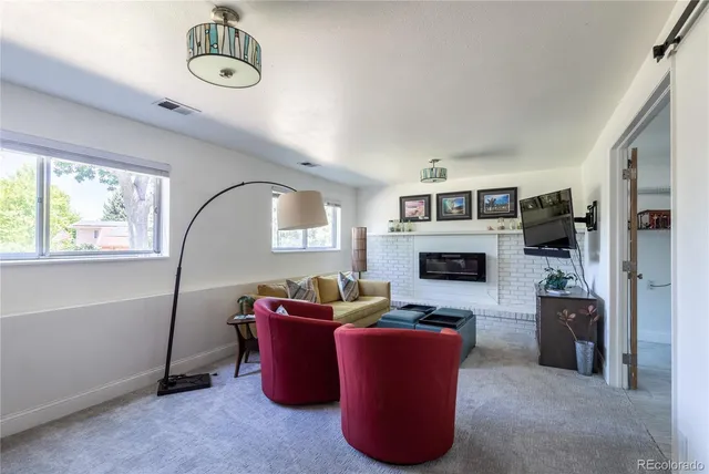 a living room with furniture a fireplace and a large window