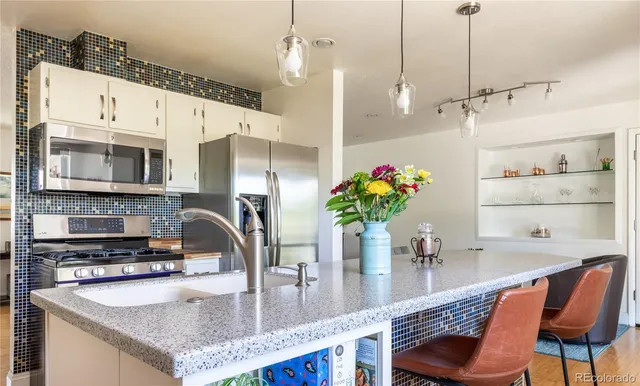a kitchen with stainless steel appliances granite countertop a sink a stove and a wooden cabinets