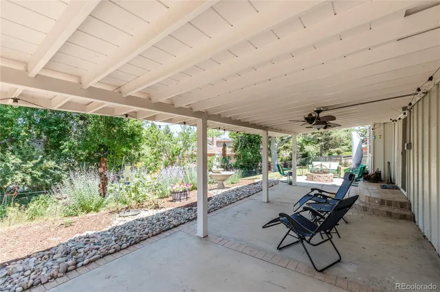a view of a patio with table and chairs potted plants and a palm tree