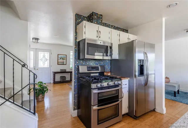 a kitchen with stainless steel appliances a stove a microwave and a hard wood floor