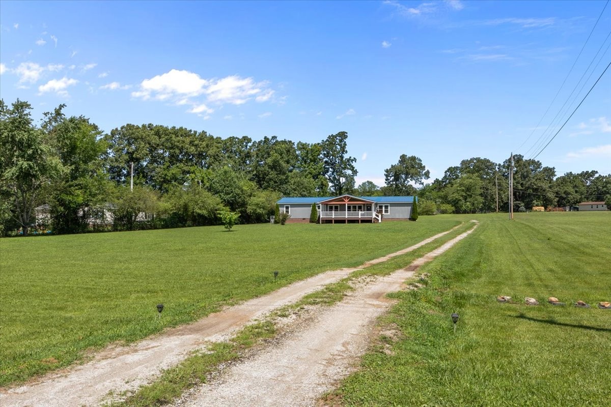 1112 Garners Creek Road Dickson, TN 37055 - Photo 34 of 57 a view of a garden with a building in the background