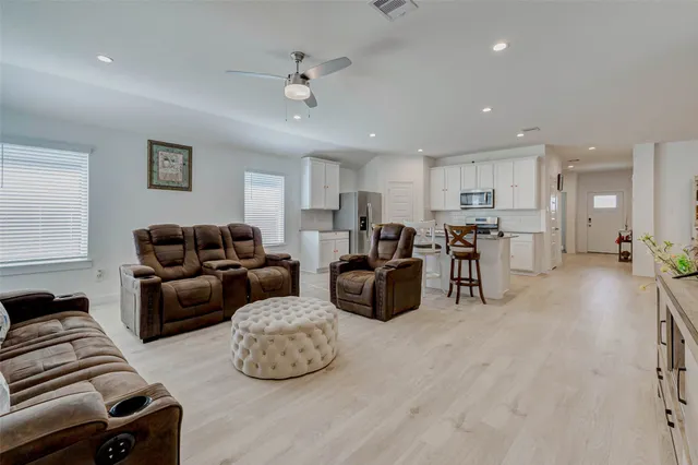 a living room with furniture and a ceiling fan