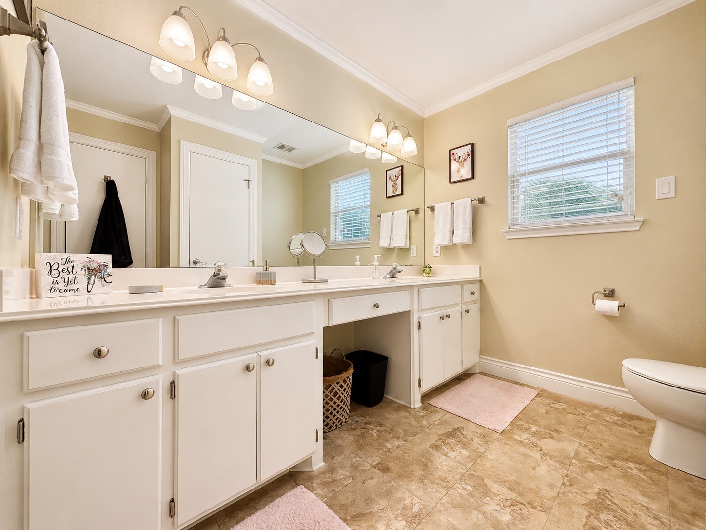 135 Sand Shoals Road Freeport, TX 77541 - Photo 14 of 20 Bright and spacious bathroom with dual sinks, ample cabinetry, and elegant lighting. Features a large mirror, tiled floors, and a window for natural light.