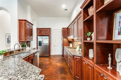 a kitchen with granite countertop a sink and a wooden cabinets