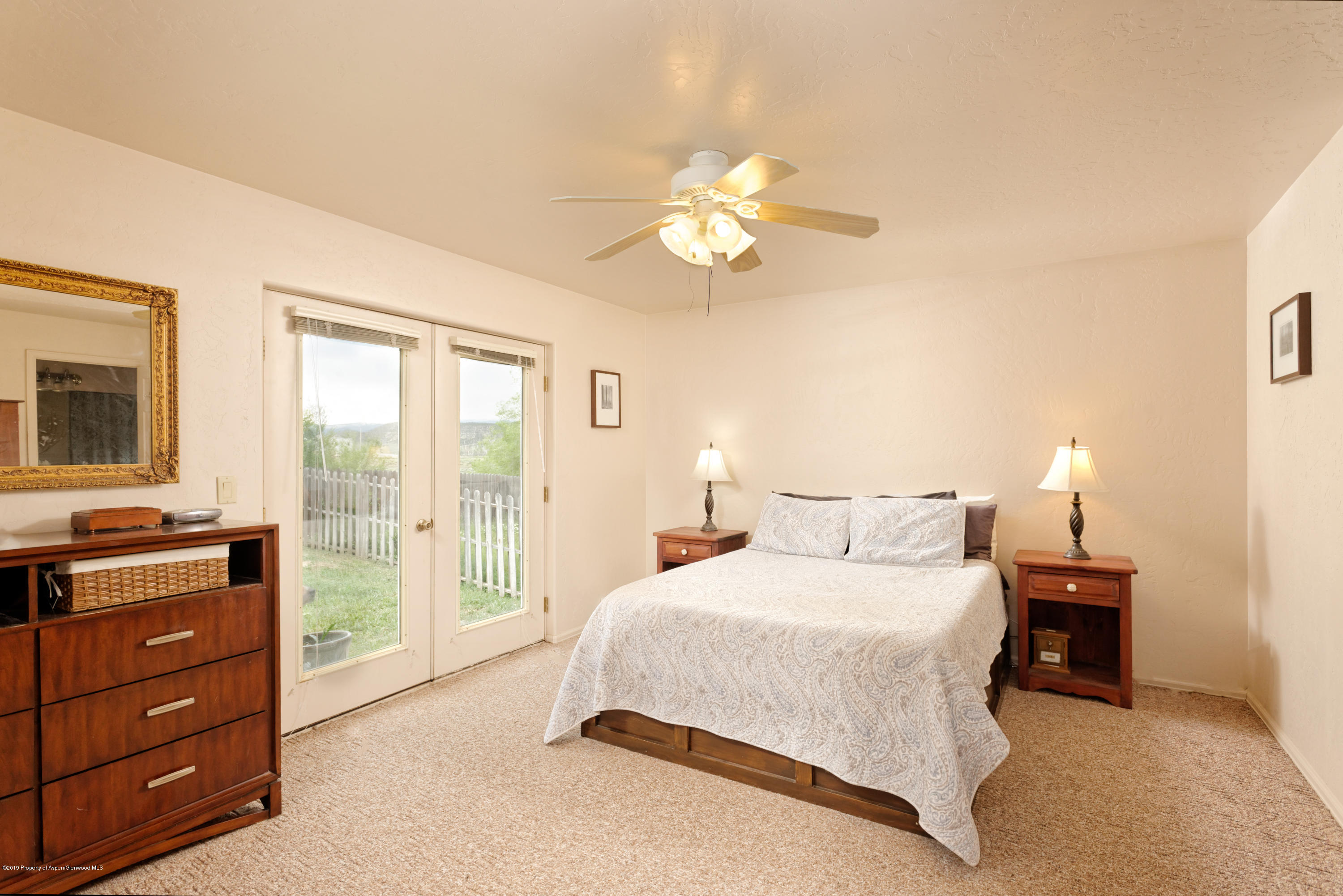 560 Birch Court Rifle, CO 81650 - Photo 8 of 18 a bedroom with a bed and a chandelier