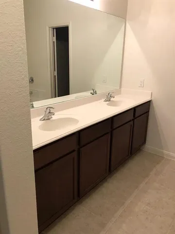 a bathroom with a double vanity sink and large mirror