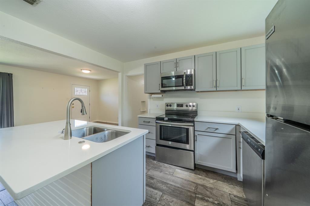 11528 Sinclair Avenue Dallas, TX 75218 - Photo 6 of 16 Kitchen featuring a spacious island with an undermount dual-basin sink and a gooseneck faucet