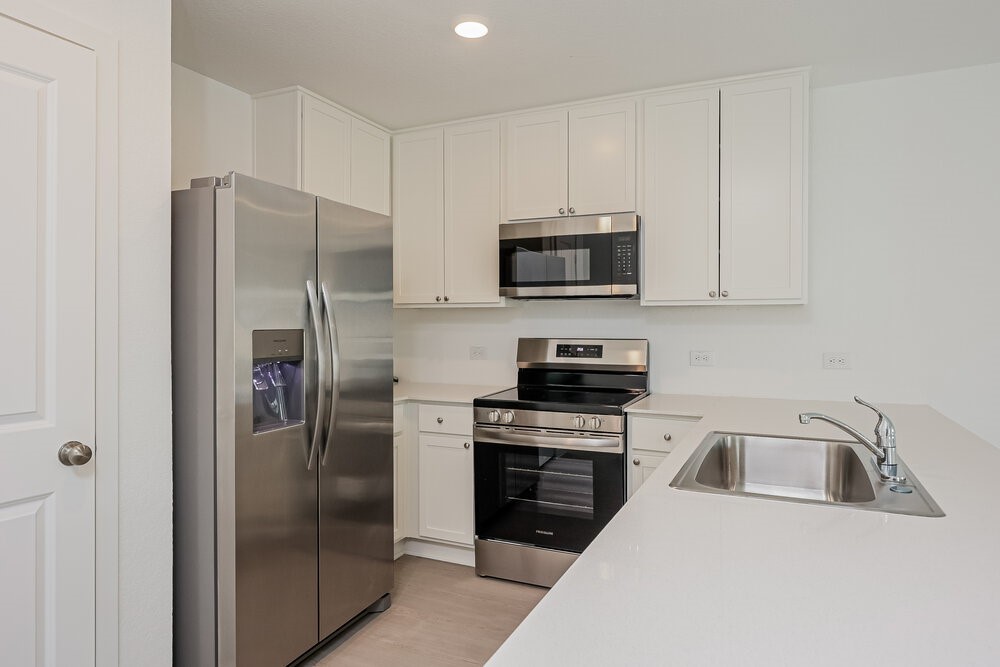 621 Craven Street Conroe, TX 77316 - Photo 5 of 16 a kitchen with stainless steel appliances a refrigerator sink and microwave