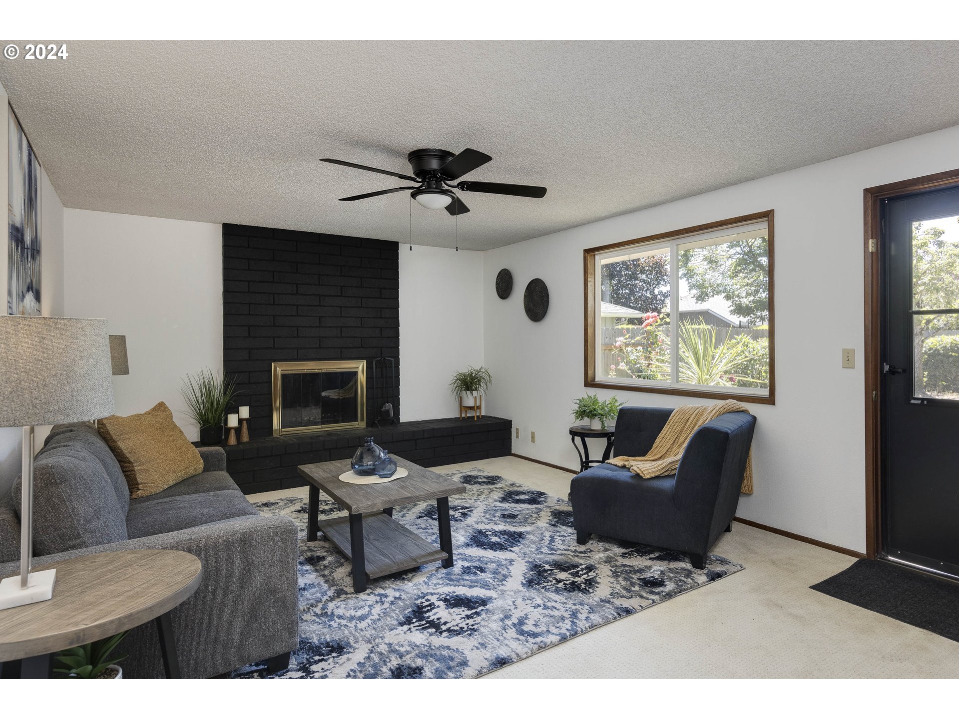2466 Erin Way Eugene, OR 97408 - Photo 13 of 31 a living room with furniture a fireplace and a flat screen tv