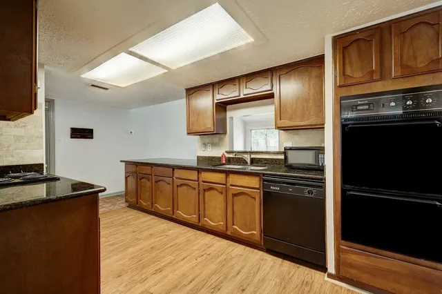 a kitchen with granite countertop stainless steel appliances and wooden cabinets