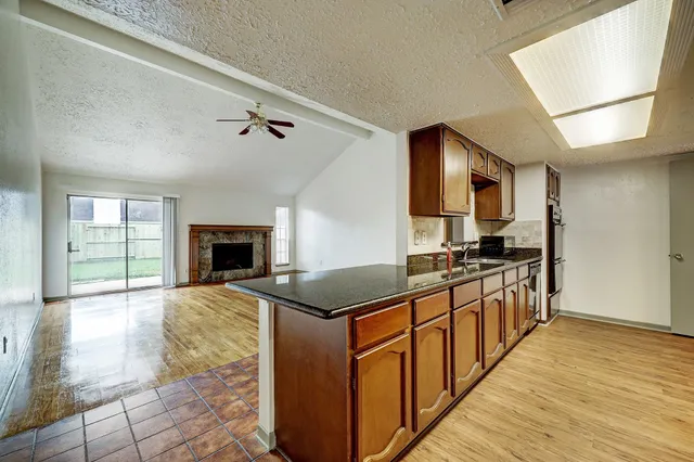 a kitchen with granite countertop a stove top oven sink and cabinets