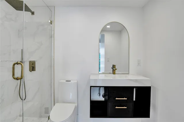 a bathroom with a sink vanity toilet and shower
