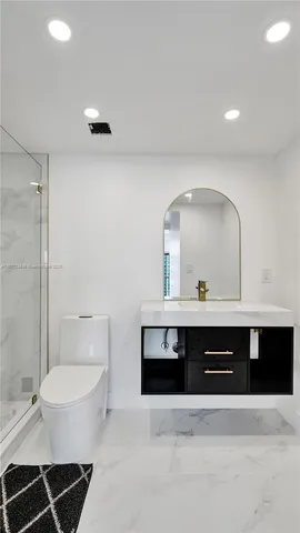 a bathroom with a sink a toilet and a mirror