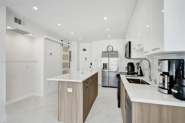 a kitchen with white cabinets and stainless steel appliances
