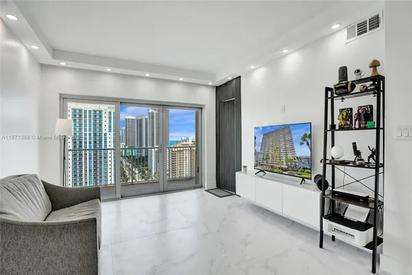 a living room with furniture a flat screen tv and a floor to ceiling window