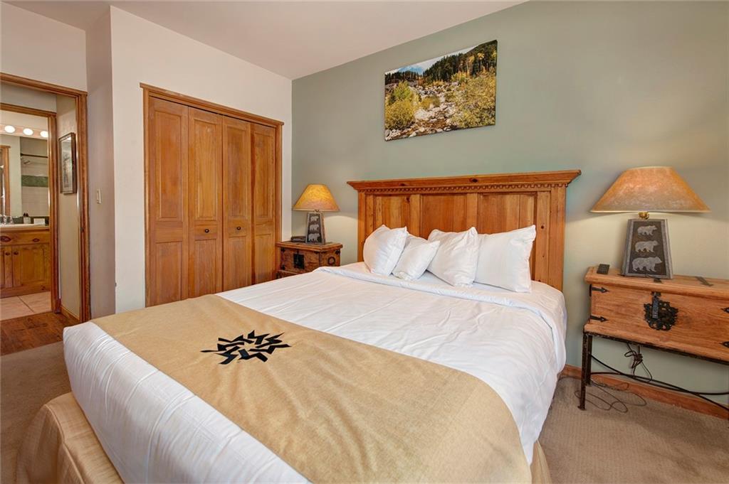 129 River Run Road, Unit 8058 Keystone, CO 80435 - Photo 19 of 35 a bedroom with a bed and a lamp on dresser