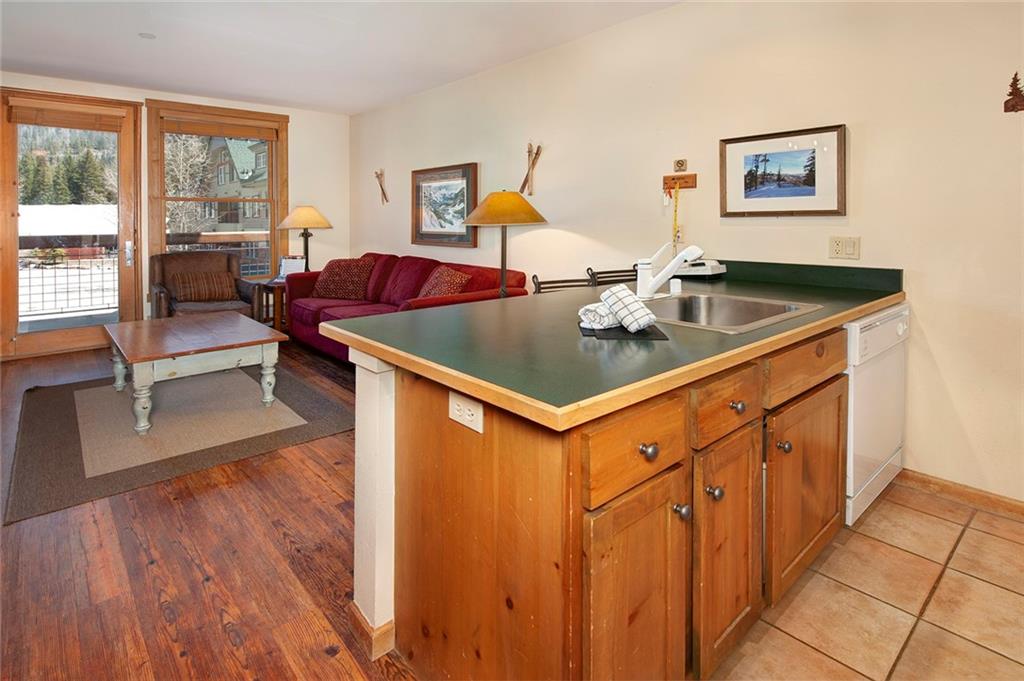 129 River Run Road, Unit 8058 Keystone, CO 80435 - Photo 5 of 35 a living room with stainless steel appliances granite countertop a couch and a dining table with wooden floor