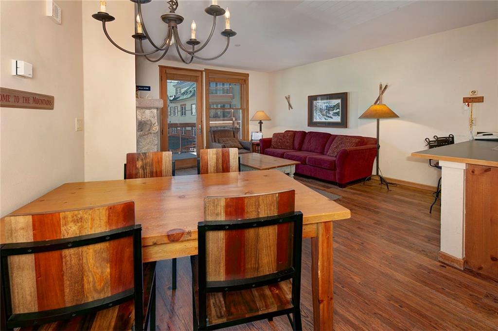 129 River Run Road, Unit 8058 Keystone, CO 80435 - Photo 6 of 35 a view of a dining room with furniture a chandelier and wooden floor