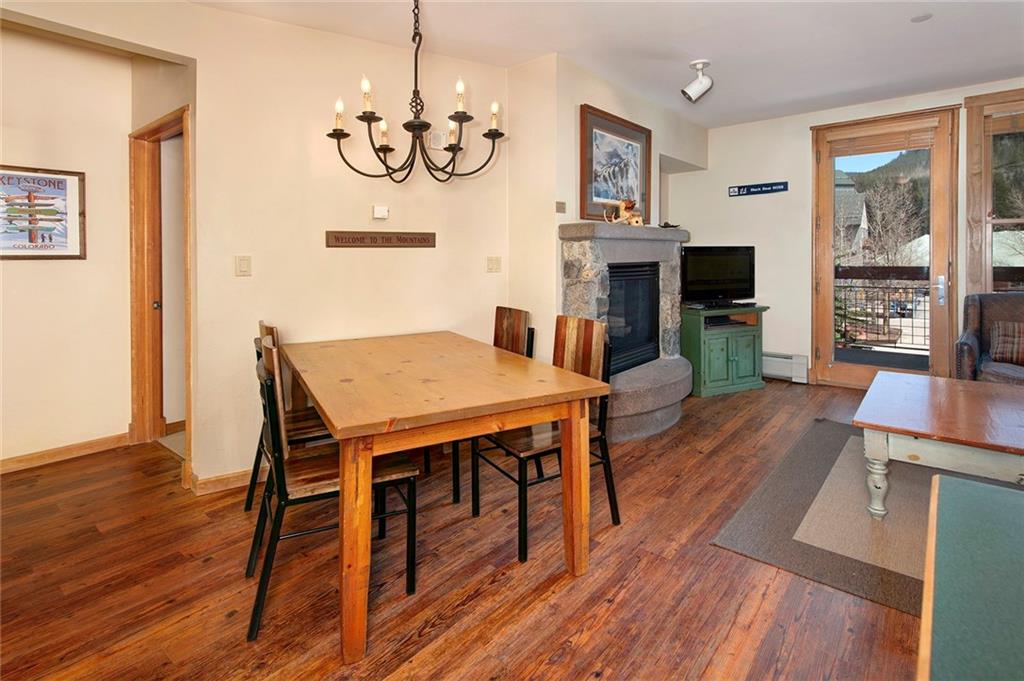 129 River Run Road, Unit 8058 Keystone, CO 80435 - Photo 7 of 35 a view of a dining room with furniture a chandelier and wooden floor