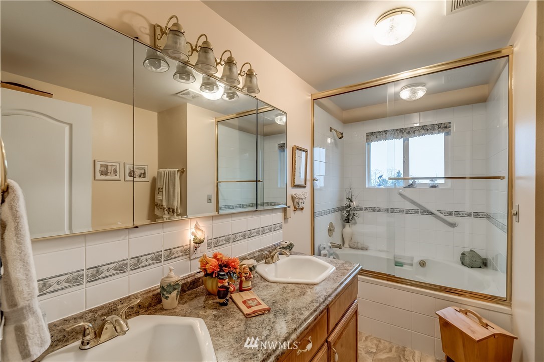 8883 North Pass Road Sumas, WA 98295 - Photo 21 of 25 a bathroom with a granite countertop sink a mirror and a bathtub