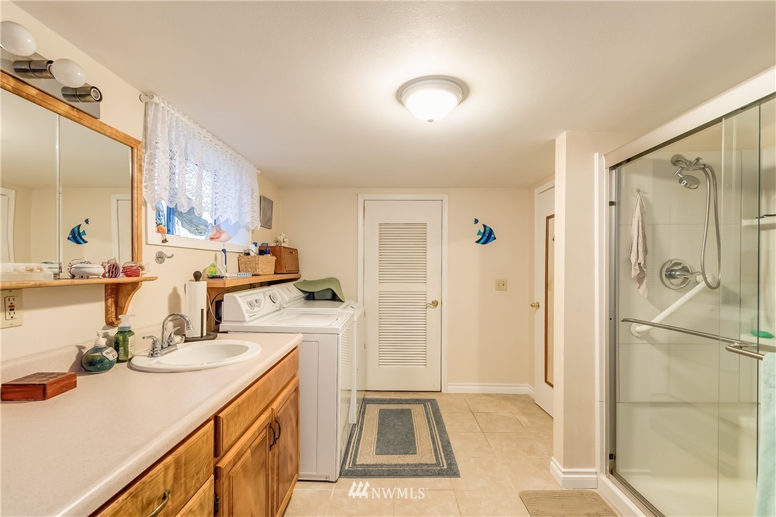 8883 North Pass Road Sumas, WA 98295 - Photo 23 of 25 a bathroom with a sink a mirror and a shower