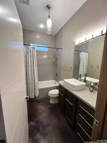 a bathroom with a granite countertop sink toilet a mirror and shower