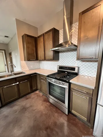 a kitchen with granite countertop a stove and a sink