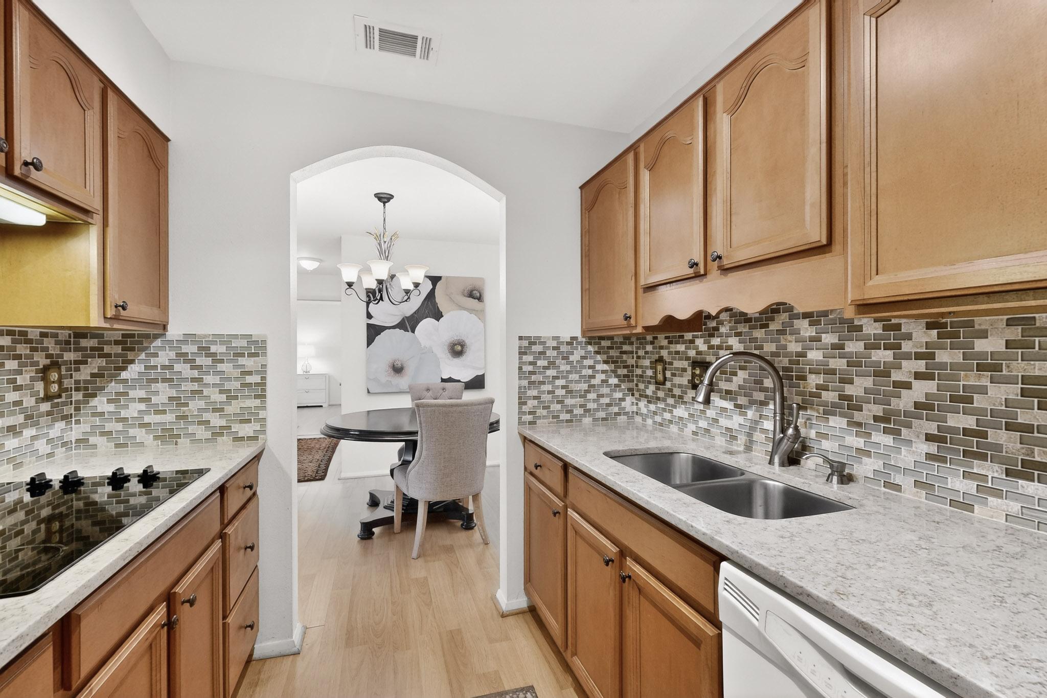 8210 Bent Tree Road, Unit 104 Austin, TX 78759 - Photo 12 of 39 Kitchen featuring light stone counters, dishwasher, and black electric cooktop
