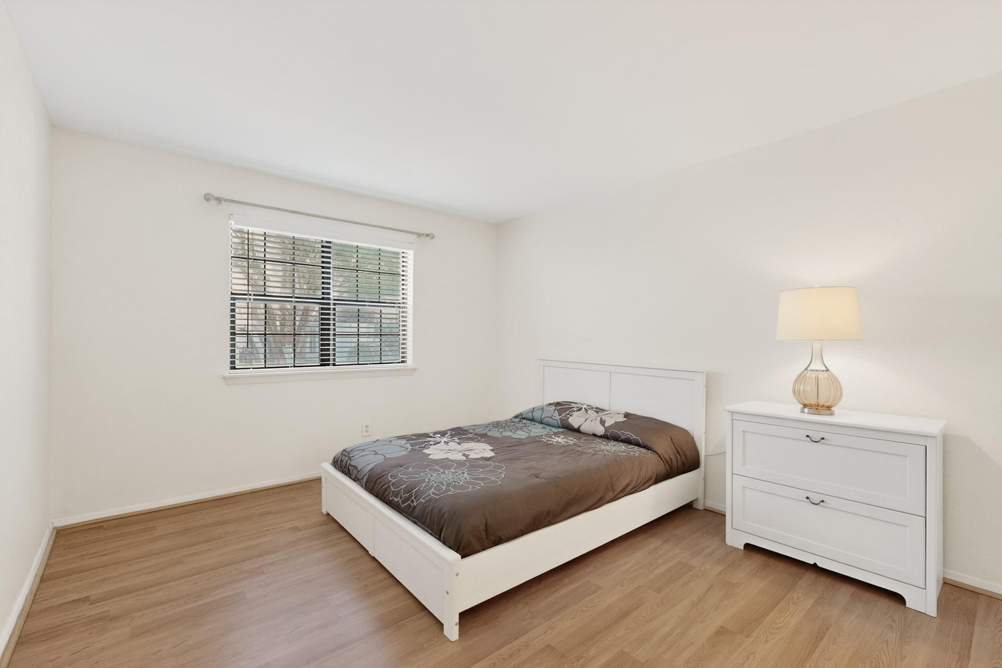 8210 Bent Tree Road, Unit 104 Austin, TX 78759 - Photo 15 of 39 Bedroom featuring light wood-style flooring and baseboards