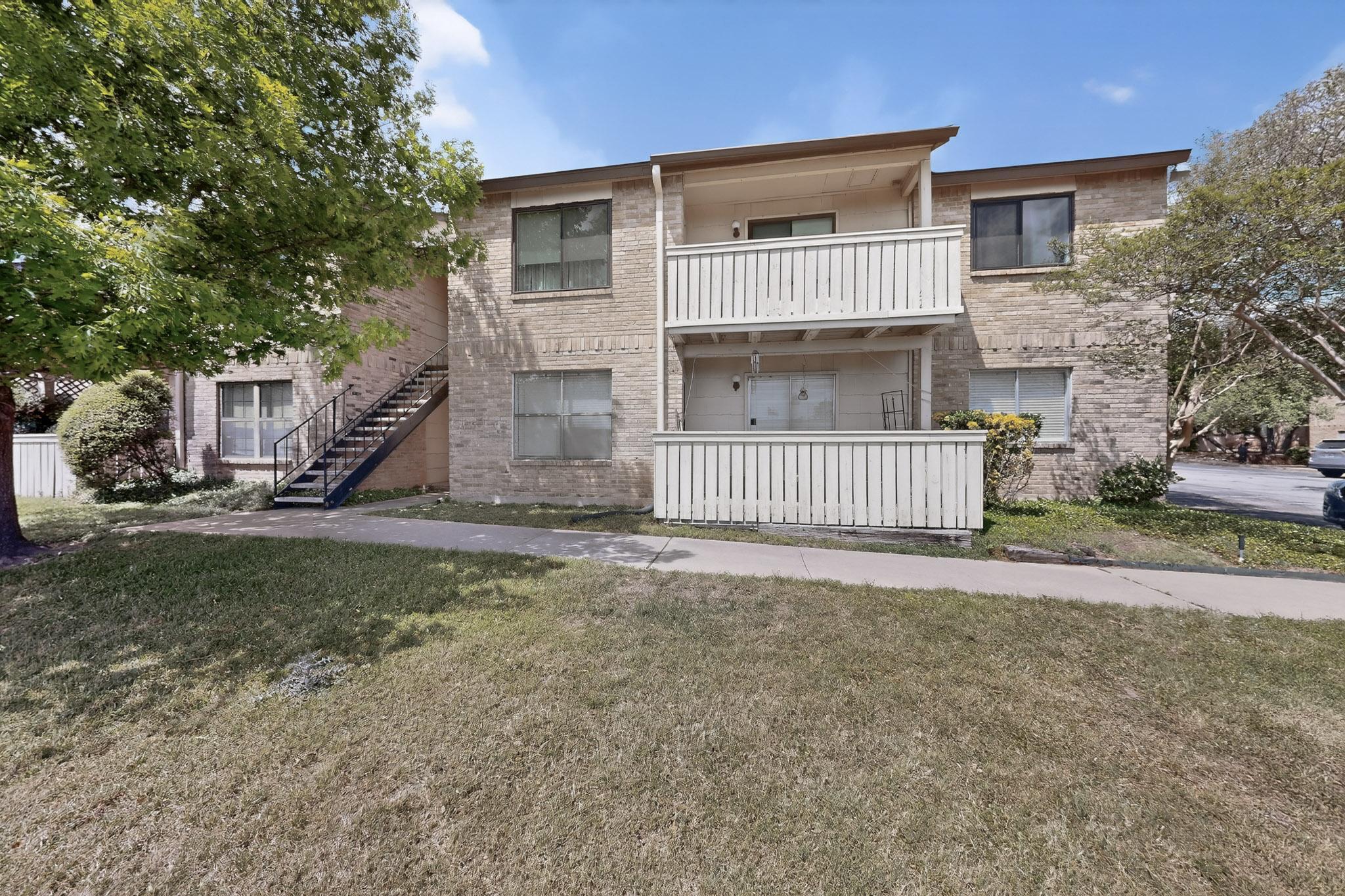 8210 Bent Tree Road, Unit 104 Austin, TX 78759 - Photo 2 of 39 View of front of home featuring a balcony, a front yard, and brick siding