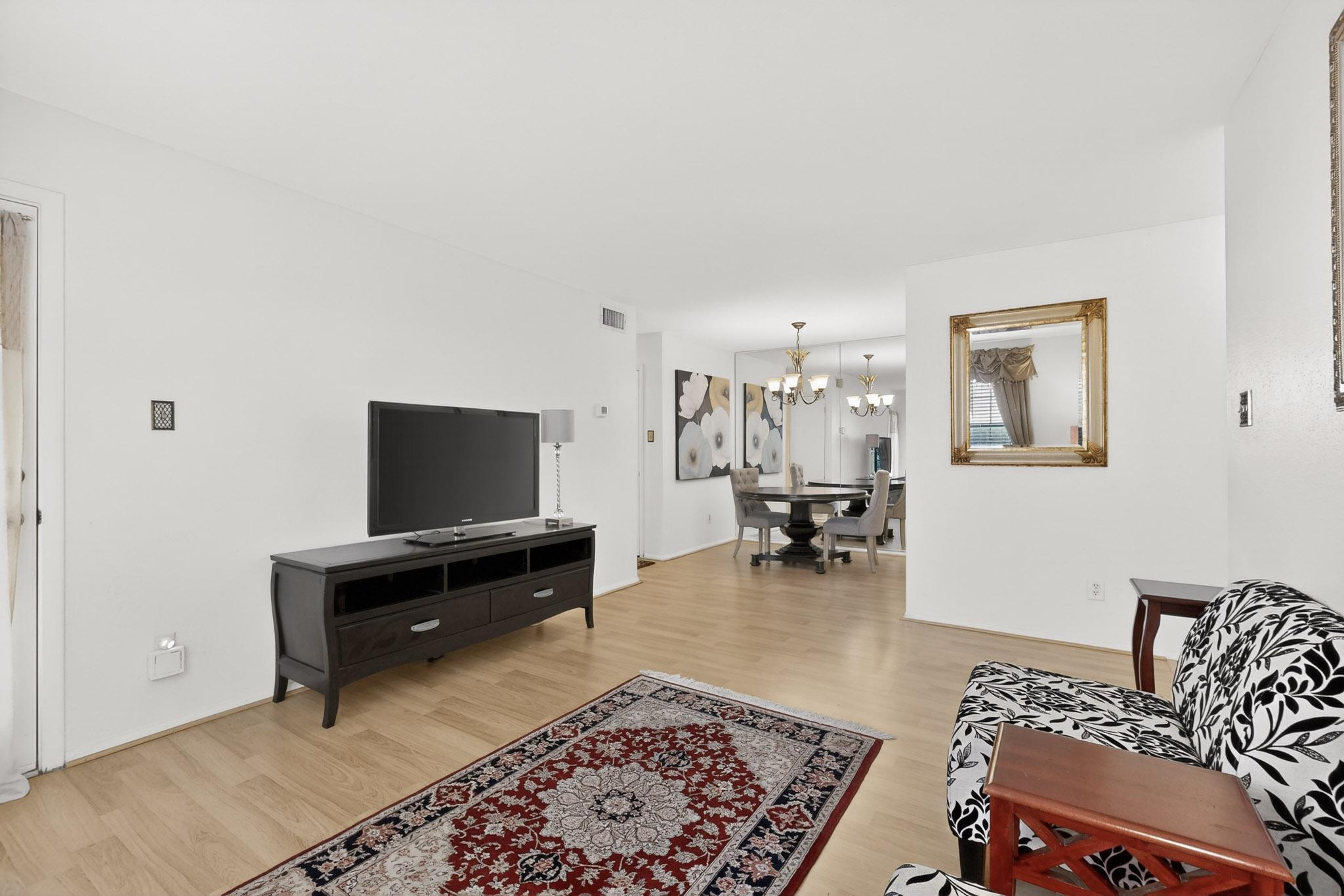 8210 Bent Tree Road, Unit 104 Austin, TX 78759 - Photo 5 of 39 Living room featuring light wood-style flooring and hanging lights