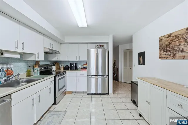 a kitchen with a refrigerator sink and cabinets