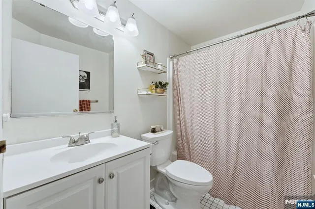 a bathroom with a granite countertop sink a toilet and a mirror