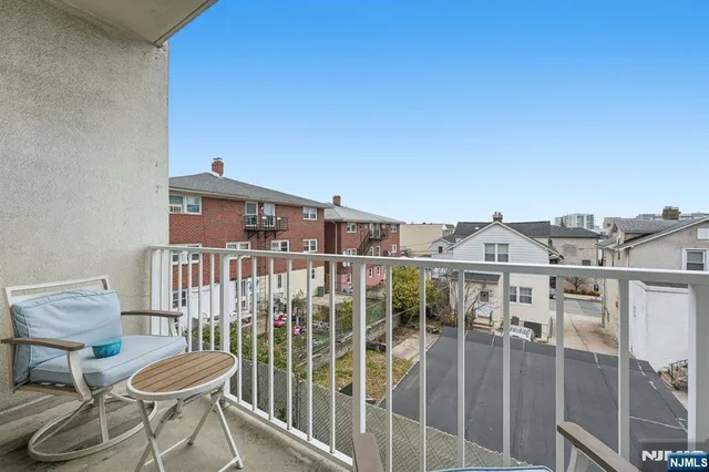 a view of a balcony with a chair and potted plants