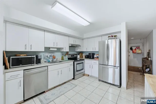 a kitchen with cabinets stainless steel appliances and a counter space