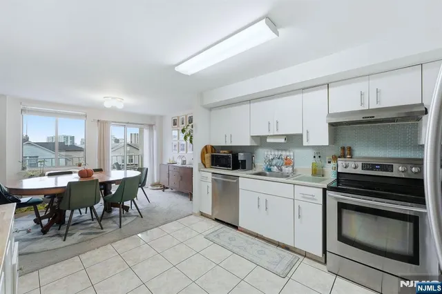 a kitchen with a stove a sink and chairs