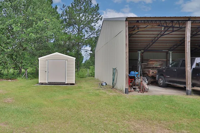 a view of a backyard with table and chairs and a large tree