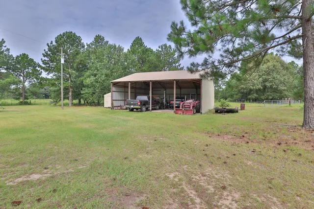 a view of a house with a yard and large trees
